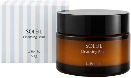 Szklany słoik w kolorze bursztynu z Soleil Cleansing Balm obok pasekowego opakowania.