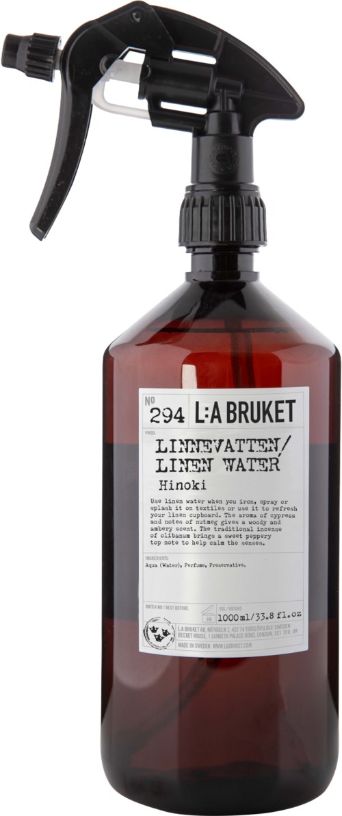 A brown spray bottle with a black trigger and a white label, containing liquid for cleaning or watering plants.