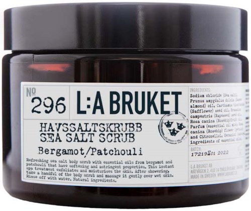 Sea salt scrub with bergamot and patchouli scent in a black jar. It has a white label with product details.