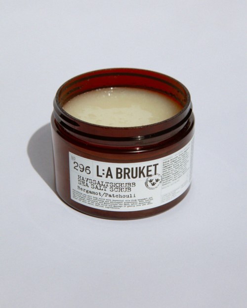 A brown jar with a white label contains salt scrub named 'L:A BRUKET' on a white background.