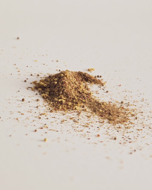 A small pile of ground spices or herbs on a white surface.