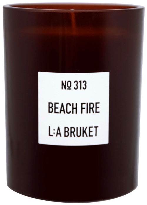 A dark brown candle in a container, labeled 'Beach Fire'.