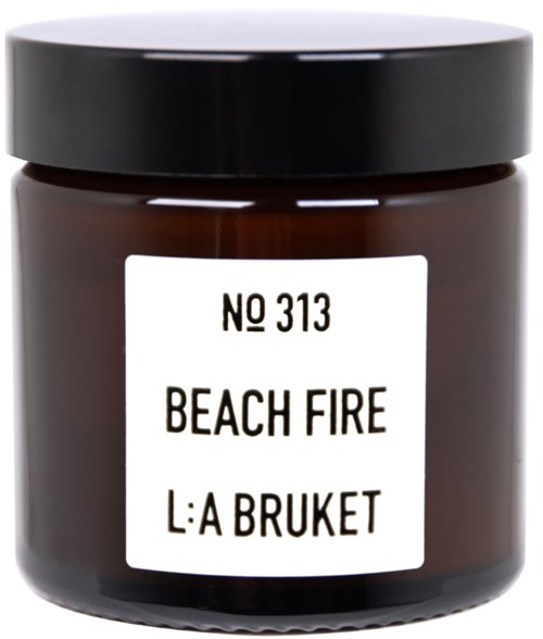 A jar with a black lid labeled "Beach Fire" and "L:A Bruket" in black text.