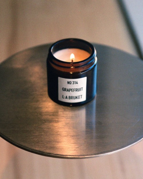 A candle with a label 'Grapefruit' on a table with a modern look.