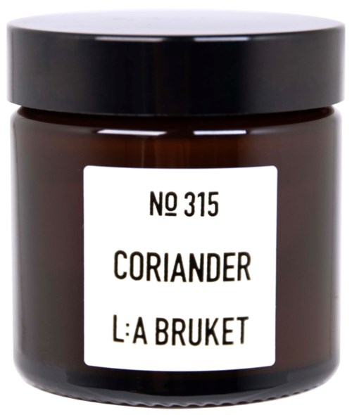 Een kleine pot met label 'Koriander' en een zwarte deksel.