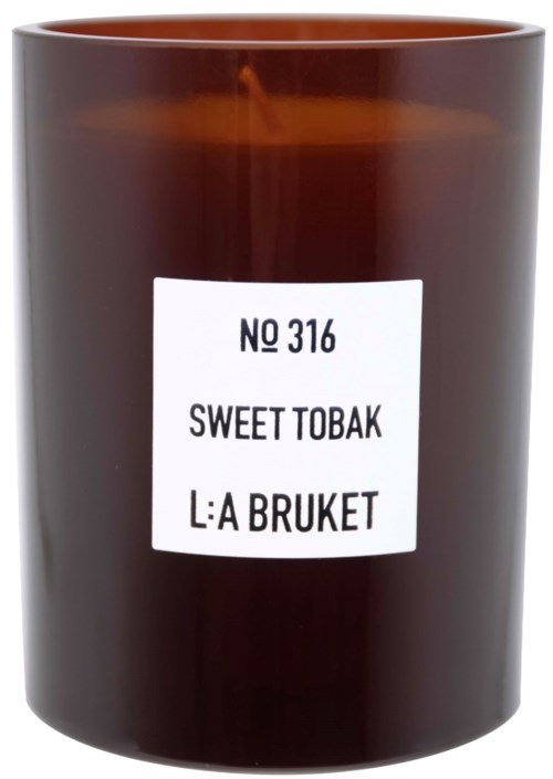 A brown candle in a jar with a label that says 'No 316 Sweet Tobak L:A Bruket'.
