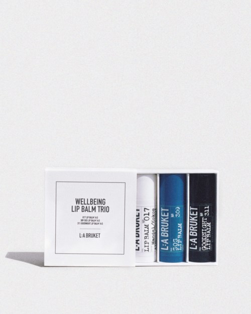 A set of three lip balms in a white box with simple black text and blue and black packaging.