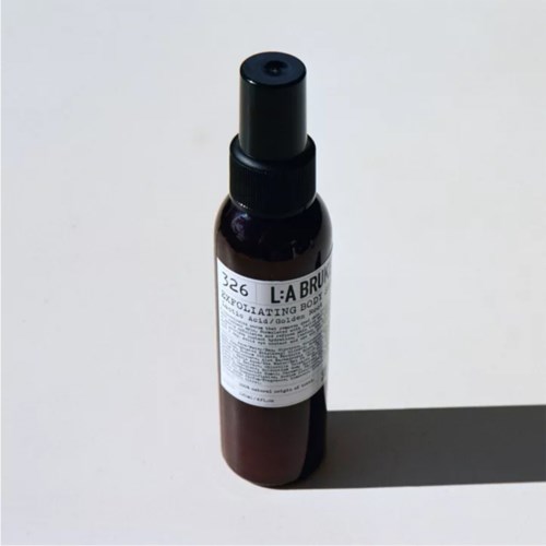 A small brown spray bottle with a black cap and white label, sitting on a white surface with a shadow.