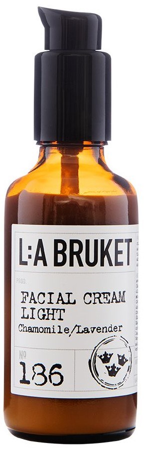 En liten bärnstensfärgad flaska med svart pump som innehåller L:A BRUKET ansiktskräm ljus, med kamomill och lavendel doft.