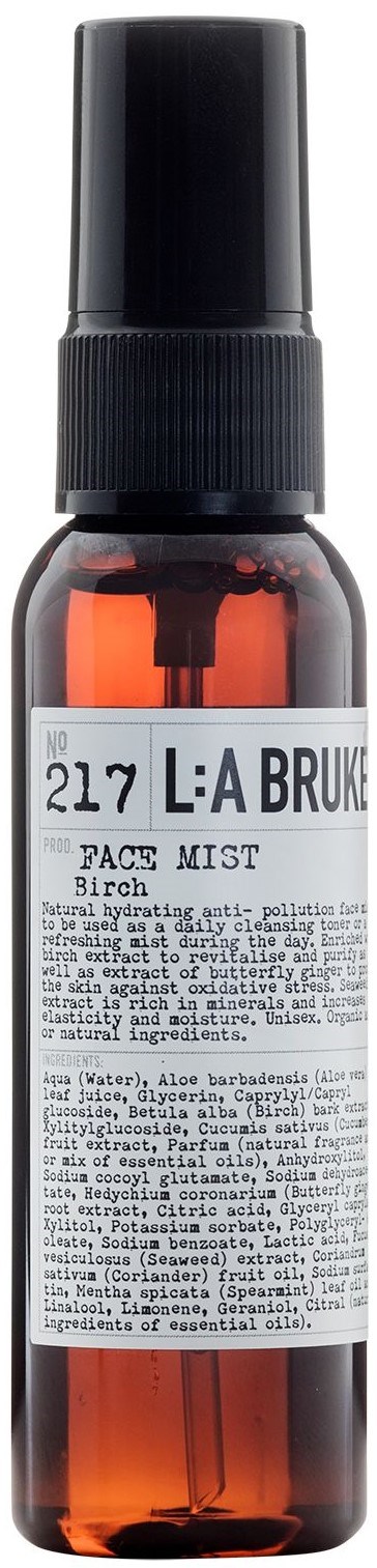 A small amber spray bottle labeled 'L:A Bruket' with a black cap, likely a facial mist or skincare product.