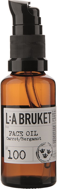 En liten brun glasflaska med svart pump, märkt 'L:A BRUKET Face Oil' med ingredienserna morot och bergamot.