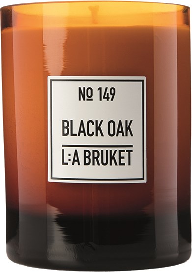Ett stort ljus i bärnstonsfärg med en vit etikett som säger "No 149 Black Oak La Bruket."