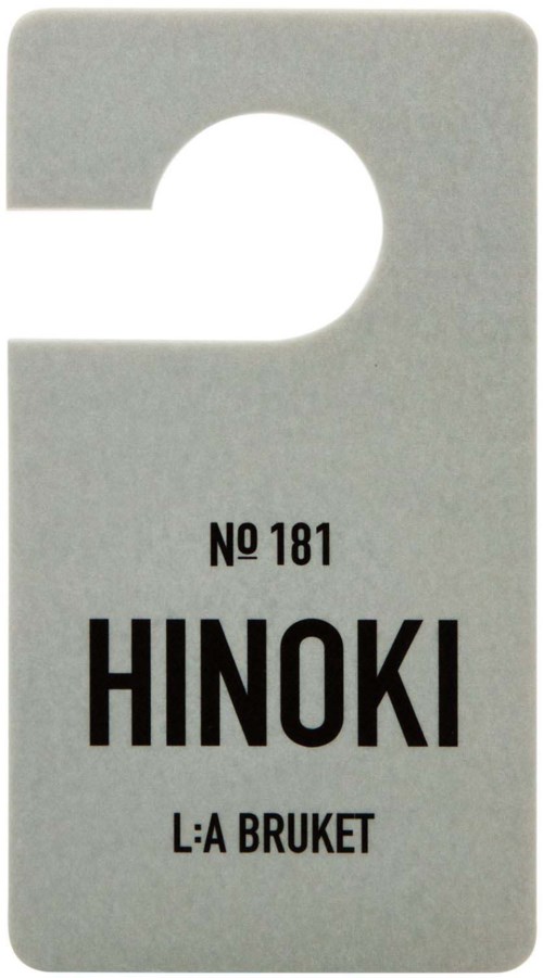 A small gray label with a hole at the top, showing the text: NO 181, HINOKI, L:A BRUKET.