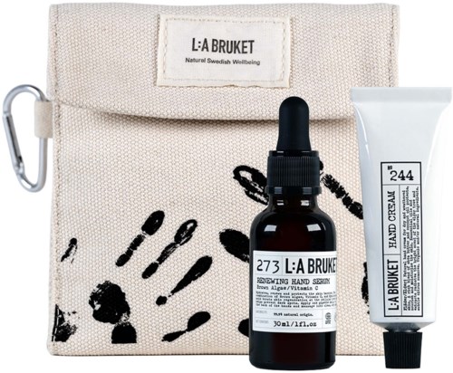 A skincare set with a bag, serum bottle with dropper, and cream tube, all labeled with natural ingredients.