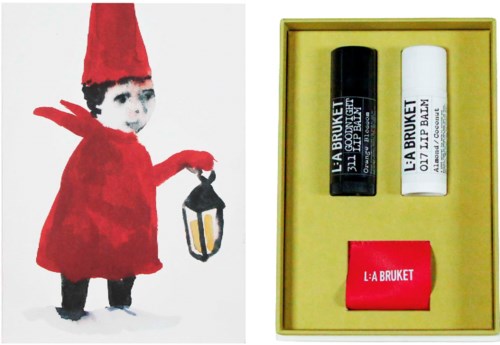 En fantasifuld illustration af en lille nisse med rød hat og kappe, der holder en lanterne, ved siden af en gul æske med hudplejeprodukter.