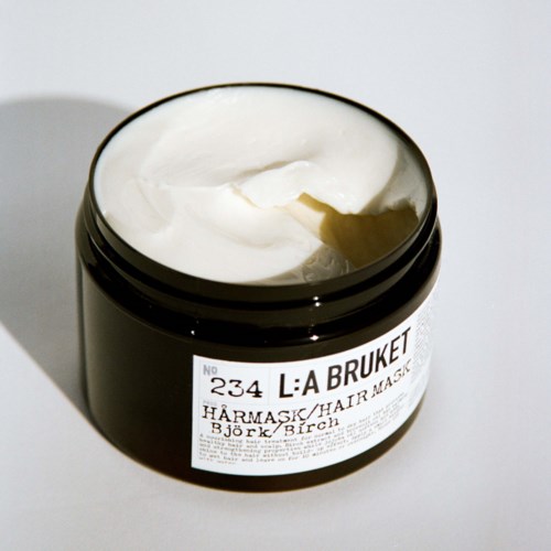 Open black jar with white cream, label says L:A BRUKET, hair or skin mask, with birch scent.