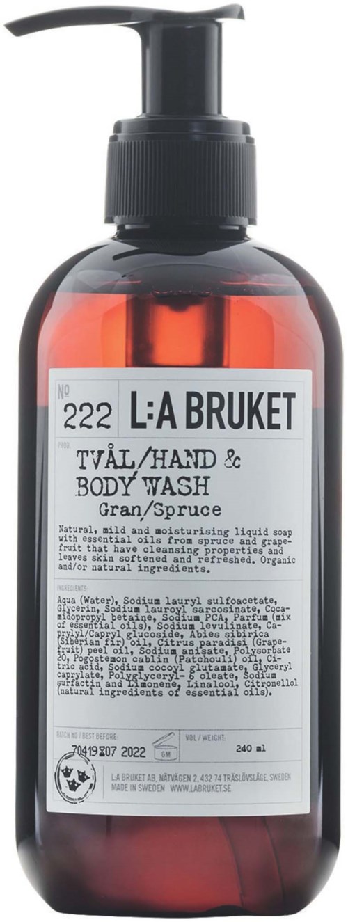 A brown bottle with a black pump contains hand and body wash labeled 'L:A BRUKET', with scent 'Gran/Spruce', and detailed text.
