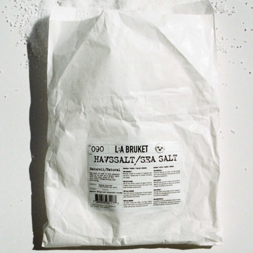 En skrynklig vit papperspåse med et märke som säger "Sea Salt" och information om produkten.