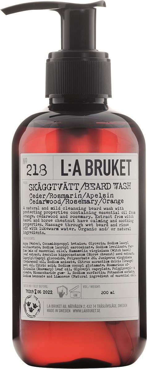 En röd flaska med pump som innehåller skäggtvätt med naturliga ingredienser och en etikett.