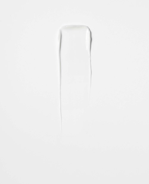 A white background with a faint, vertical, irregular mark or scratch in the center.