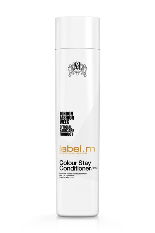 En lång vit flaska med svart och guldig text, märkt som Colour Stay Conditioner för hårvård.