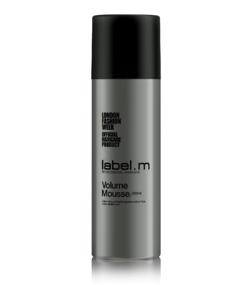 En silver- och svart burk med label.m Volym Mousse för hårstyling.