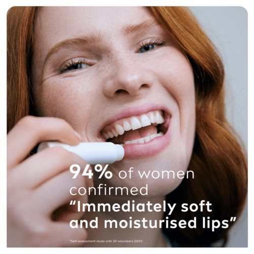 Young woman smiling while testing lip moisture, with text about women confirming soft, moist lips.