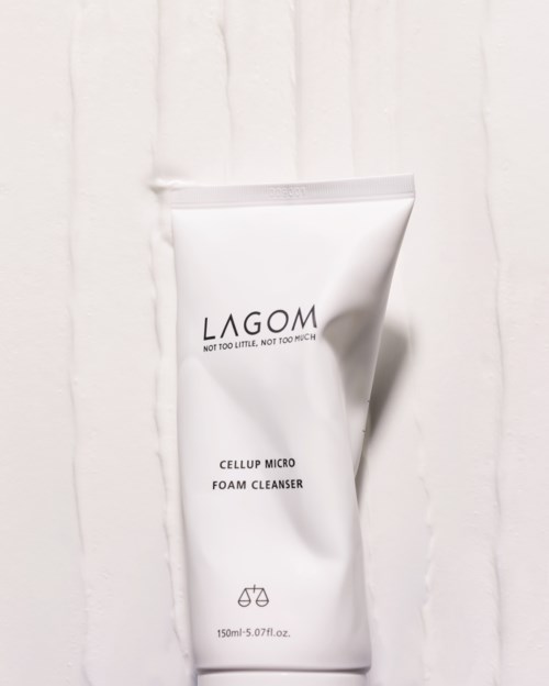 En vit tub med LAGOM Cellup Micro Foam Cleanser på en vit texturerad bakgrund.