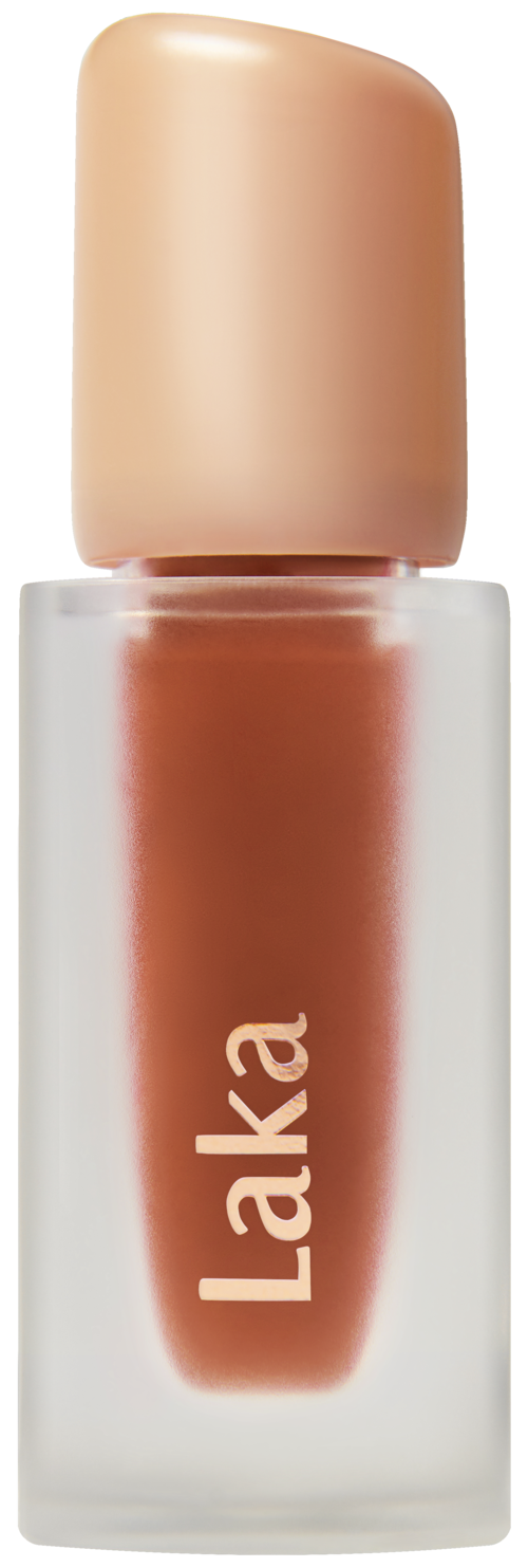 A small bottle with a beige cap, labeled 'Laka', contains a cosmetic or skincare product.