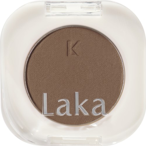 En rund brun øyenskygge i en hvit kompakt med gjennomsiktig lokk, merket 'Laka' og 'K'.
