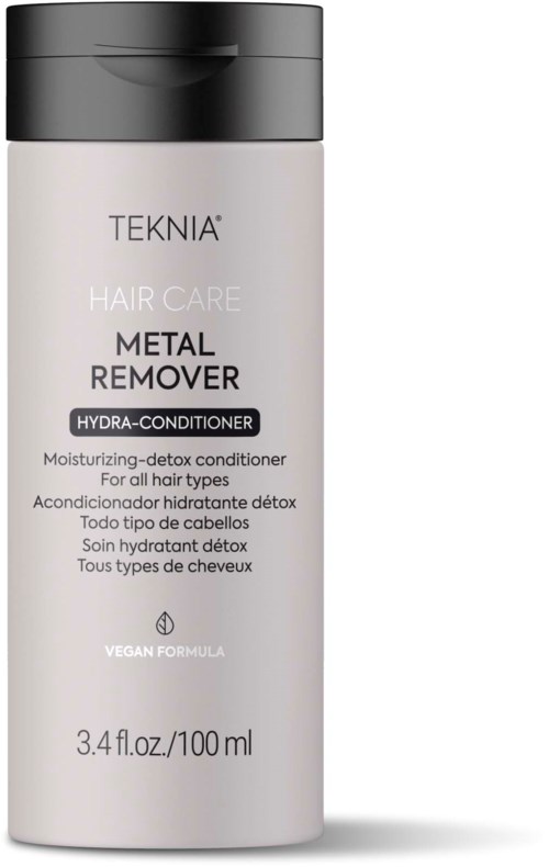 Een lange, witte fles met zwarte dop, gemarkeerd 'Teknia', voor haarverzorging, vooral metaalverwijderaar en hydraterende conditioner.