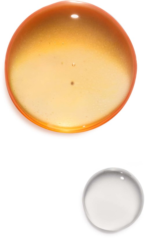 Zwei Schalen, eine große orange und eine kleine transparente, mit Flüssigkeit.