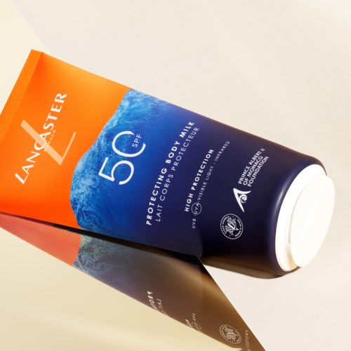 Det är en tub av Lancaster solkräm med SPF 50, för skydd mot solen. Den har en blå och orange etikett.
