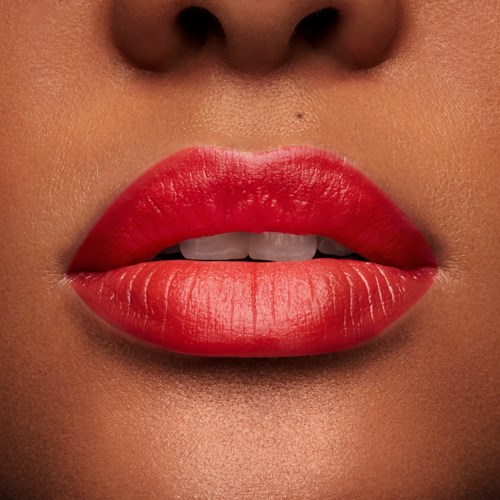 Close-up of lips painted bright red, slightly parted showing teeth, with smooth skin surrounding.