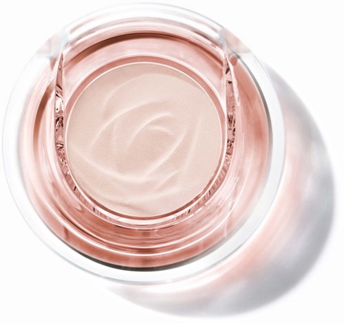 A round, shiny compact with light pink makeup or skincare product inside. The container is transparent and reflective.
