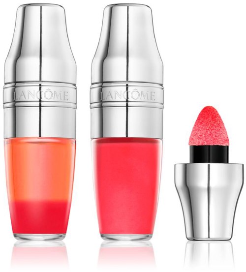 Två läppglansflaskor och en läppstift med en rosa applikator. Flaskorna är silver och klara med rosa och röda gloss.