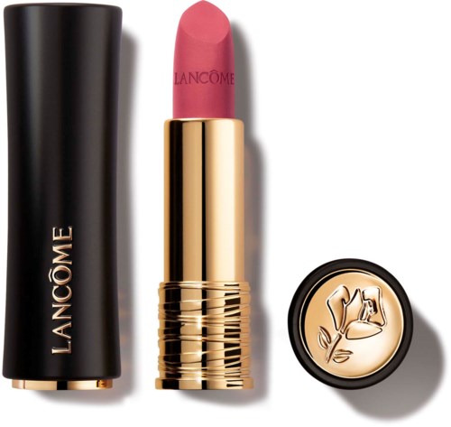Lipstick in a gold and black case with a logo, showing pink lipstick and a decorative lid with a flower design.