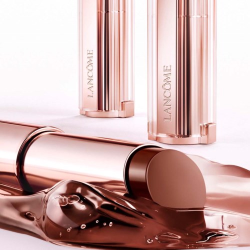 Lancôme hudpleieflasker med en rosa gullskinnende finish, noen ligger nede, andre står, på en hvit bakgrunn.