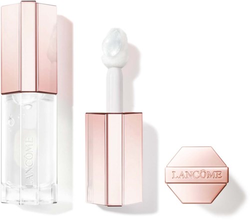 A lipstick, with the cap removed, shows a white gloss or balm inside. The case is pink and hexagonal.