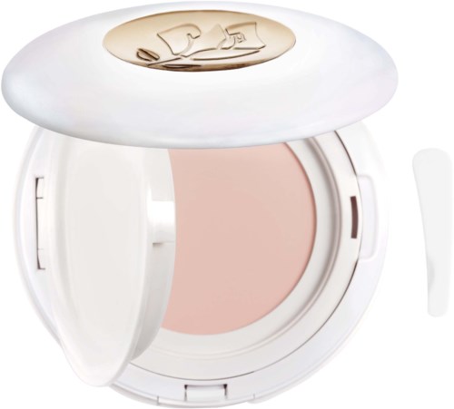A white compact with a beige powder inside, used for makeup, with a gold logo on the lid.