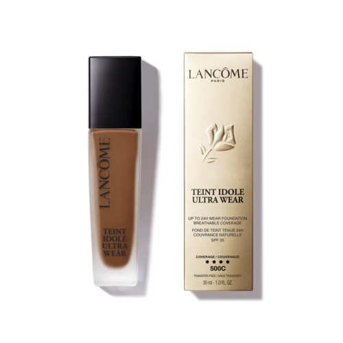 En flaska Lancôme-foundation och dess matchande förpackning, båda med eleganta designer och textdetaljer.