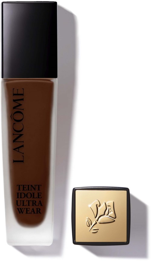 butelka podkładu Lancôme i małe kwadratowe pudełko z logo róży. Oba na białej powierzchni.