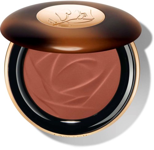 Een ronde compact met blush in een bruine houder en een gouden deksel met gegraveerd logo.