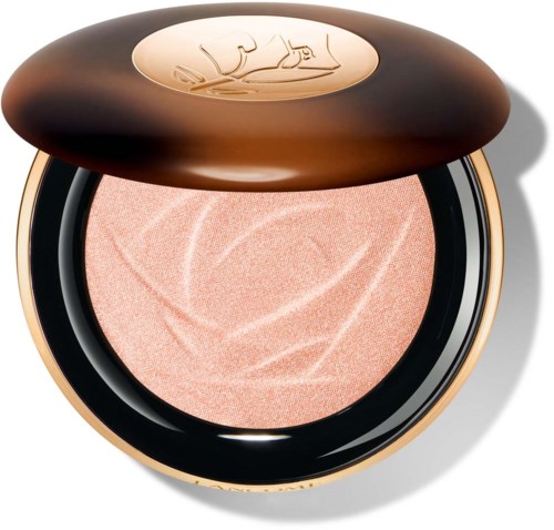 En rund makeup-kompakt med lock visar persikofärgad puder inuti med upphöjda virvlar.