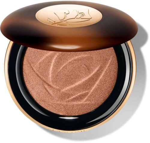 En rund makeup-variant med ögonskugga inuti, toppen har en logo eller design, och den har en metallisk eller glansig finish.