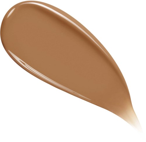 A spoon with a brownish liquid, possibly coffee, chocolate, or caramel, in it. Plain background.