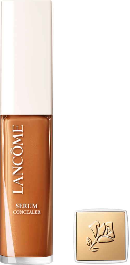 A bottle of Lancôme serum concealer with a beige cap and a beige compact nearby.