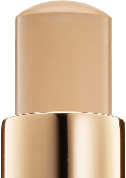 En foundation i beige nuance med et skinnende, guldfarvet låg.