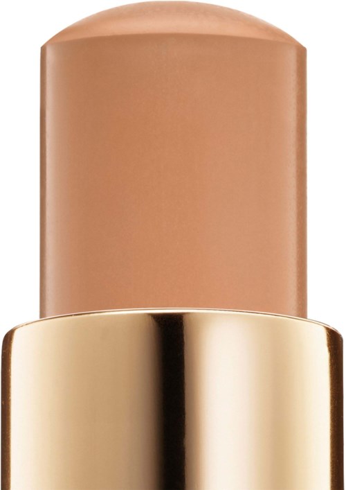 En beige pind mod en guldbeholder, med rund top og blank finish.