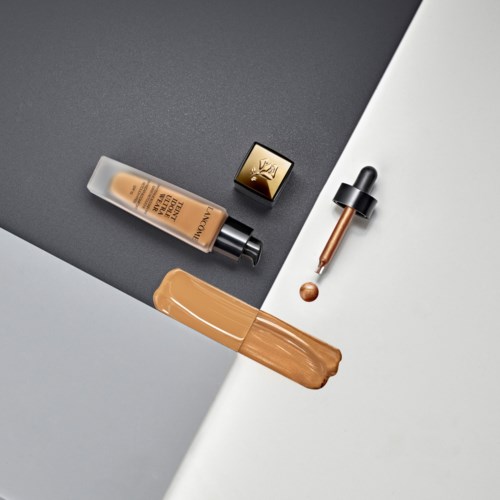 Flytende foundation, concealer med dryppespett og børste på svart og hvit bakgrunn.